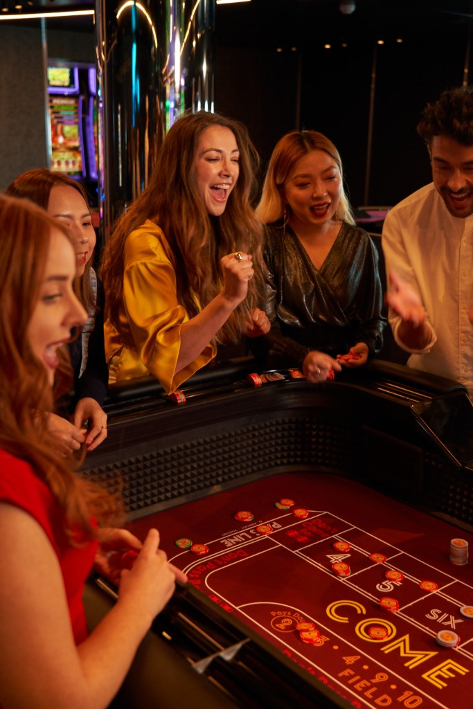 Woman celebrates a good roll with a group at the Casino.